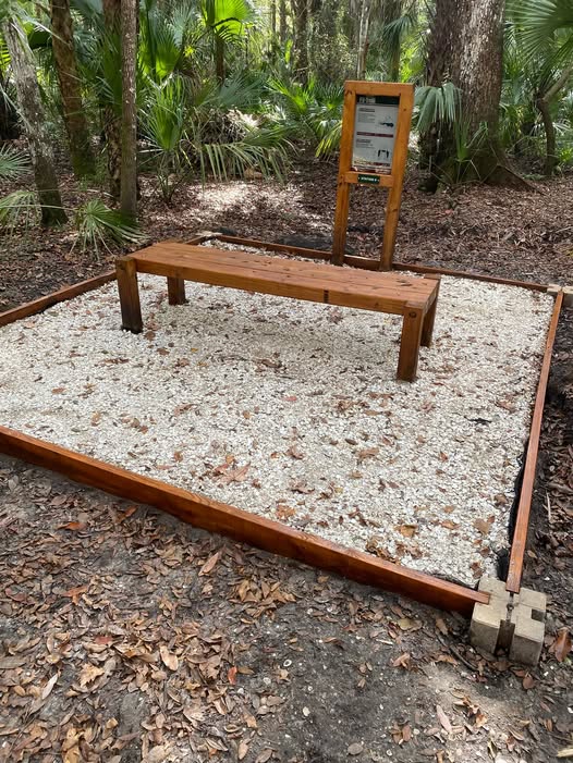 Another completed fitness station showing the stained bench, gravel pad, and Fit Trail instruction sign